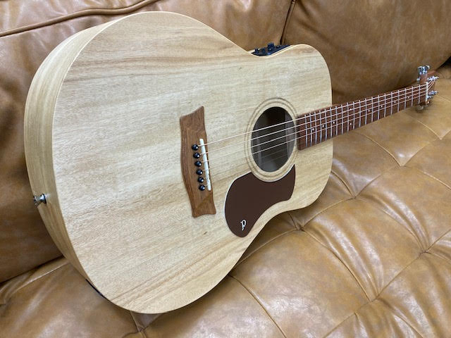 Acoustic guitar on a brown leather couch