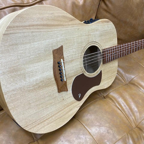 Acoustic guitar on a brown leather couch